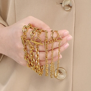 Macro detail of layered gold stainless steel chains with OT toggle clasp on model