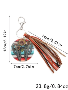 Detail of round acrylic keychain with cactus floral print and multi-color leather tassels