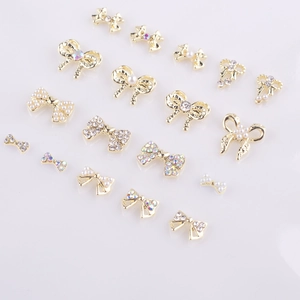 Détail de bijoux d'ongles en alliage en forme de nœud avec perles et strass brillants