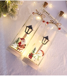 Detail of LED Christmas glass jars with Santa and Snowman prints on warm wooden base