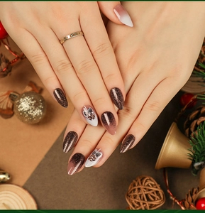 Detail of Christmas gradient brown nails with glitter and 3D metallic flower accents