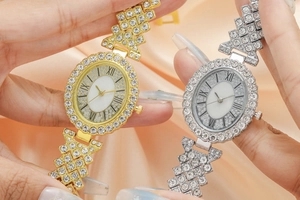 Detail view of gold and silver ladies' quartz watches with rhinestone inlay on pink silk