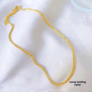 Detail of gold titanium star chain with lobster clasp and adjustable link over fabric