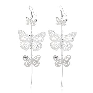 Détail de boucles d'oreilles pendantes en argent avec papillons et design élégant