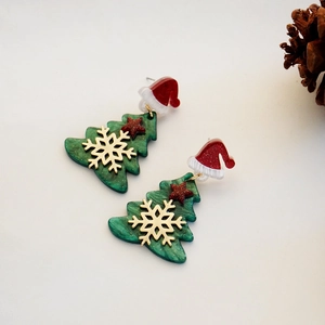 Christmas tree earrings with red hat and gold stars on a festive winter background