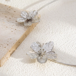 Close-up of metallic flower detail on silver minimalist open choker for women