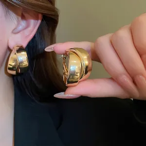 Chunky double layer layered gold hoop earrings with polished metal finish for women