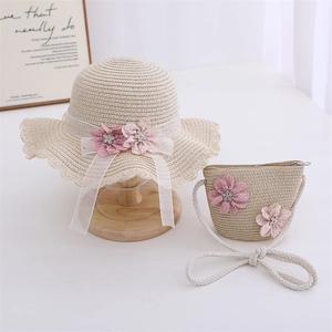 Détails du chapeau de paille et du sac assorti avec fleurs roses et filet blanc