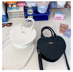 Vue de dessus de sacs à main en forme de cœur avec motif crocodile noir et blanc