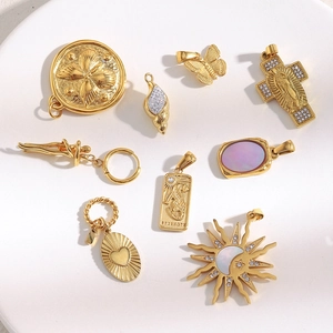 Close-up of 18K gold plated charms including bee coins and shell zircon designs