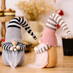 Close-up of plush Christmas gnomes with striped hats and tiny coffee cups on a wooden tray
