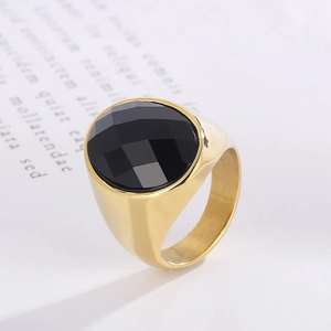 Macro side view of a gold plated ring featuring a multifaceted round black gemstone