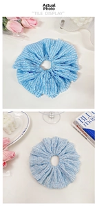Macro view of blue and white striped oversized scrunchie with pleated fabric texture