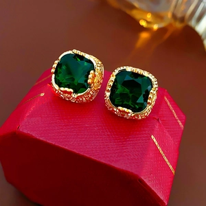 Macro di orecchini di zircone verde su un cofanetto portagioie rosso ottagonale