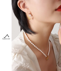 Close-up of 18K gold plated pearl necklace with OT clasp and matching drop earrings