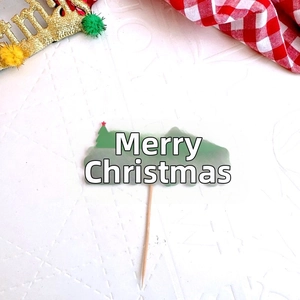 Detail of Christmas tree cake topper with Merry Xmas lettering on festive background