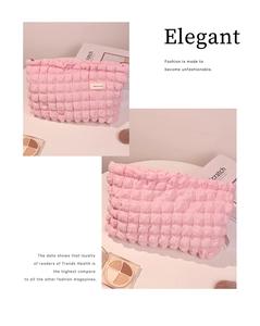 Primer plano de bolsa de maquillaje rosa con textura de burbujas 3D y etiqueta H&RBAG de tela