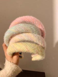 Vue détaillée de serre-têtes en peluche douce aux tons pastel rose, bleu et jaune