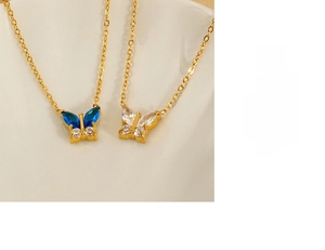Close-up of golden butterfly pendant with blue and white zircon stones inlay