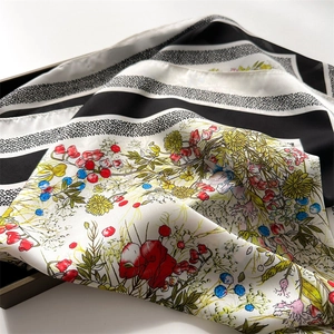Macro detail of French floral silk scarf with black white stripes in a dark tray