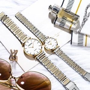 Elegant CHENXI quartz couple watches with gold and silver steel bands on a luxury background
