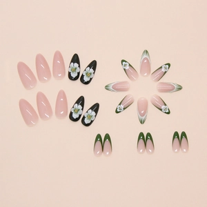 Detail of almond-shaped press-on nails with dark green French tips and 3D floral accents