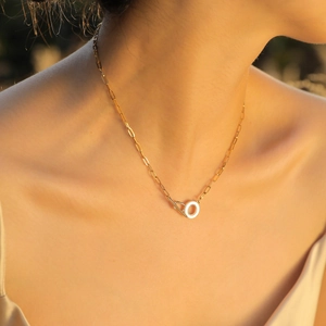 Golden rectangle link chain necklace with a round pendant on a female model