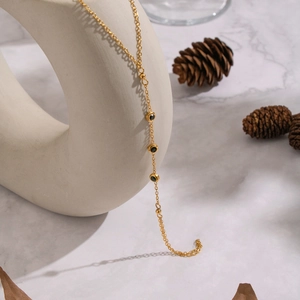 Elegant gold chain bracelet featuring circular black zircon stones and polished beads