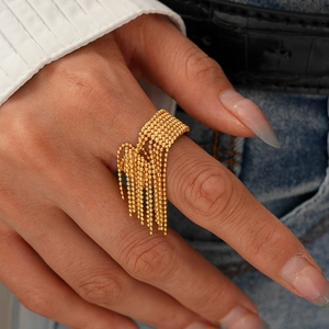 Detailansicht eines vergoldeten Edelstahl-Quastenrings an einem Model-Finger