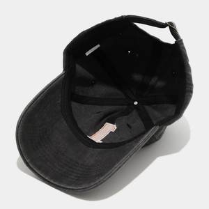 Detail of the vintage washed baseball cap showing internal cotton seams and metal buckle