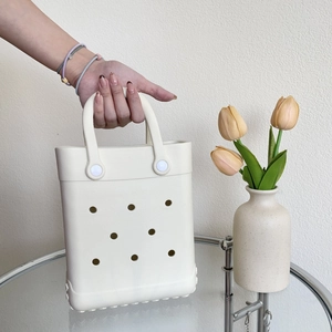 Macro view of cream EVA beach bag showing circular hole pattern and durable handle rivet