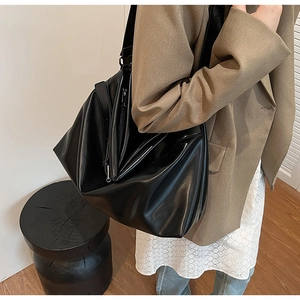 Grand sac fourre-tout noir porté avec un blazer kaki pour un style professionnel chic