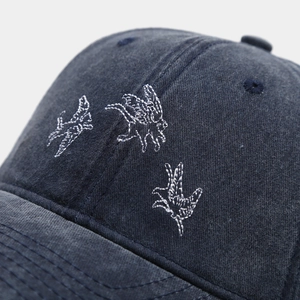 Vue détaillée de la broderie d'oiseaux blancs sur la casquette en denim délavé vintage