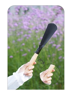 Close-up of manganese steel garden shovel with non-slip wooden handle in outdoor use