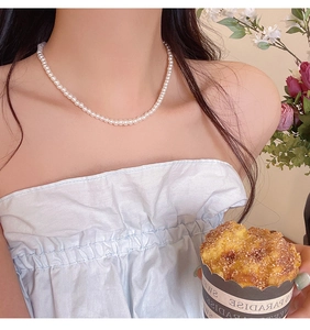 Close-up of elegant white pearl necklace worn by a model in a sweet lifestyle setting