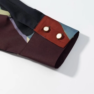 Detailed macro of a silk-textured shirt cuff with geometric patterns and two buttons