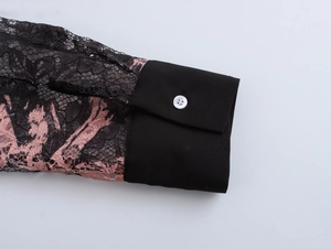 Detail of black lace sleeve with pink floral patterns and solid buttoned cuff