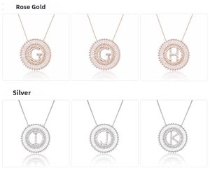 Detail of rose gold and silver circular pendants with zircon inlays and letter engravings