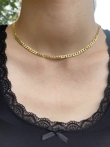 Detailed macro view of gold plated chain texture on model neck with black lace background