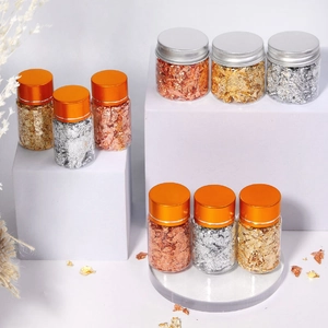 Detailed close-up of gold, silver, and rose gold metallic flakes in clear glass jars