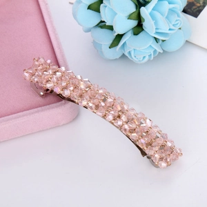 Detail of pink crystal beaded spring hair clip resting on a pink velvet jewelry box