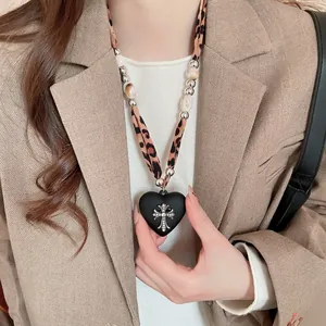 Vintage leopard print necklace with black heart pendant and silver cross detail