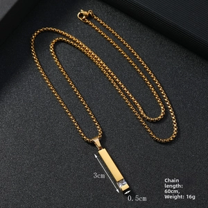 Macro shot of gold-plated box chain and crystal-inlaid rectangular pendant