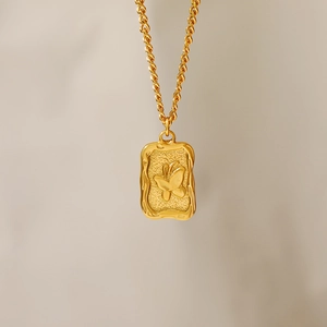 Detail of 18K gold plated rectangular pendant featuring an embossed butterfly on a link chain