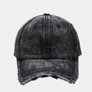 Close-up of distressed brim details on washed dark grey denim baseball cap with frayed edges