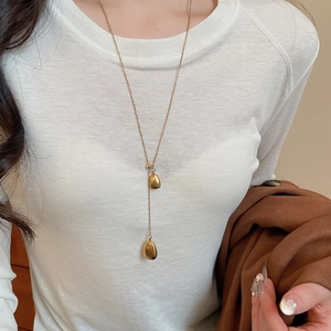 Detail of 18k gold plated Y-shaped drop necklace featuring two asymmetrical bean pendants
