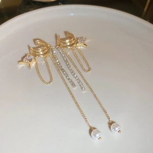 Gros plan d'un bijou d'oreille papillon doré avec perles et zircons sur une assiette