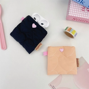 Detailed view of quilted heart pattern small earphone pouches in navy and pink colors