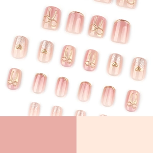 Short square pink cat eye press-on nails with 3D gold bow and glitter heart accents
