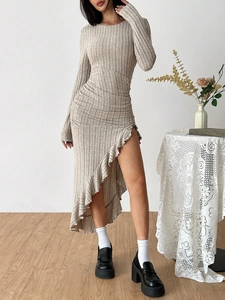 Detail of light brown ribbed knit dress featuring an asymmetric ruffled hem and side slit